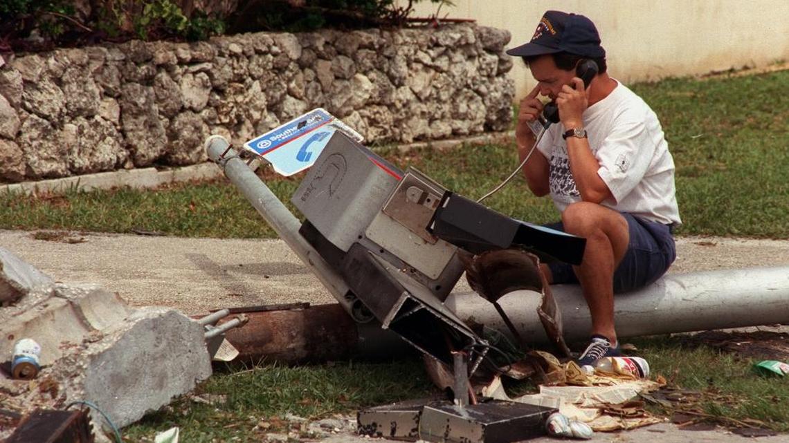 After Hurricane Andrew hit South Florida on Aug. 24, 1992, the phone booth was shattered but the pay phone continued to work. Javier Erazo uses the battered phone to call relatives in Honduras and Guatemala. So many people jammed phone lines in the aftermath of Andrew that Southern Bell officials begged people to limit their calls.