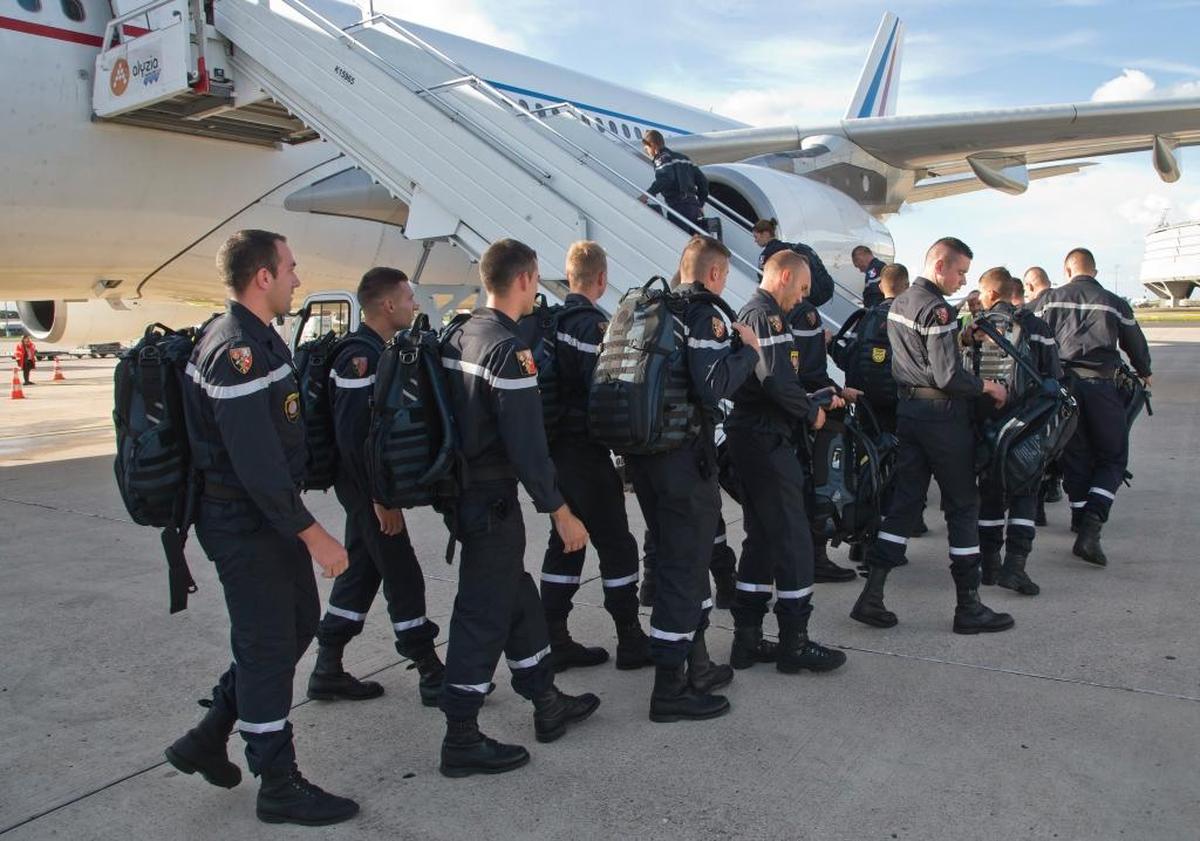 French firefighters and military rescue team board a military plane at Paris Charles de Gaulle airport in Roissy, France. They will assist with Hurricane Maria relief efforts in the French Caribbean islands. About 25,000 households lost electricity and two small towns are without potable water after Maria swiped Martinique.