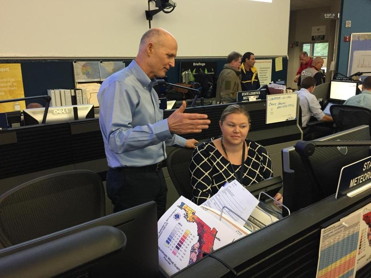 Florida Gov. Rick Scott talks with state meteorologist Amy Godsey during a visit to the main room of the state Emergency Operations Center in Tallahassee on Sept. 10, 2017, where dozens of federal and state personnel coordinate preparation and response efforts for Hurricane Irma.