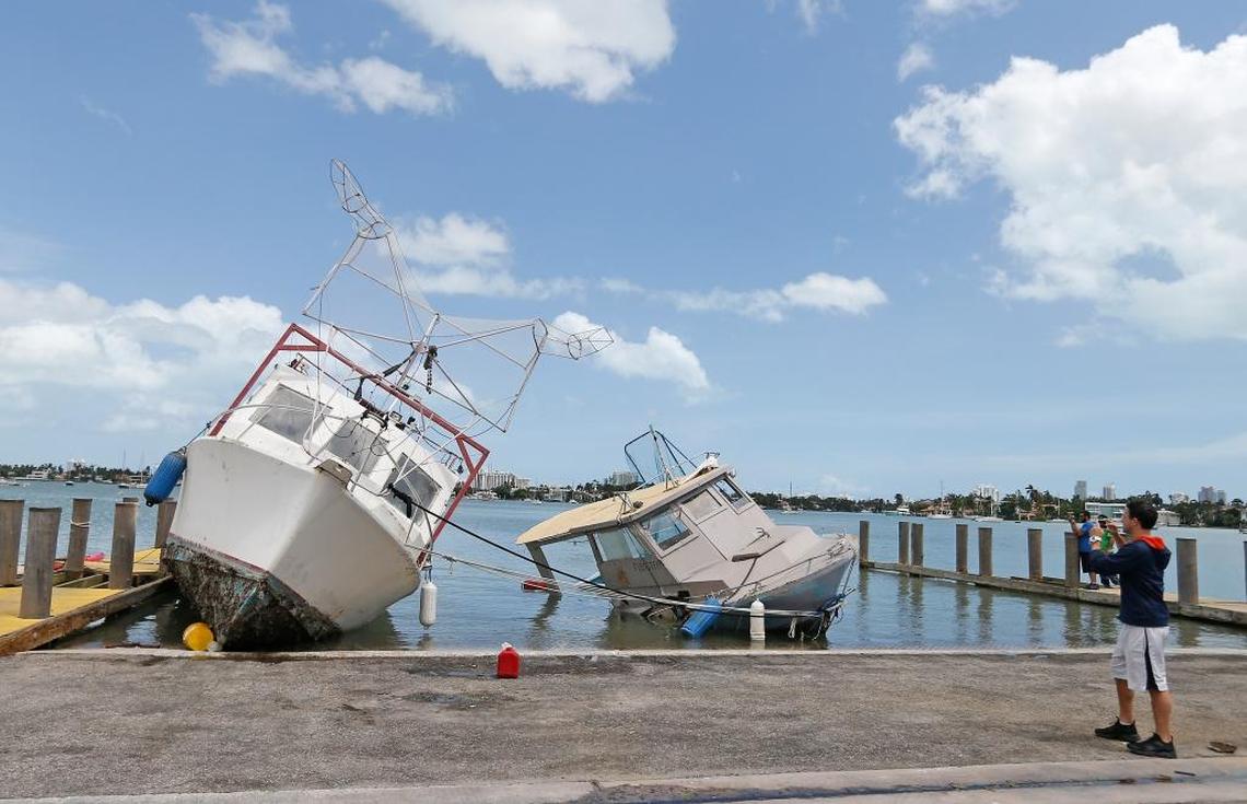 A man takes pictures of boats washed ashore at Watson Island in Hurricane Irma’s aftermath on Monday, September 11, 2017, in Miami.