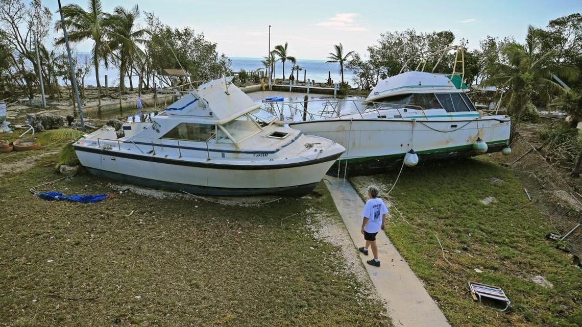 Chris Morgan walks to the large boats on Tuesday, September 12, 2017 that beached onto the property she stayed during Hurricane Irma's storm surge in Key largo.