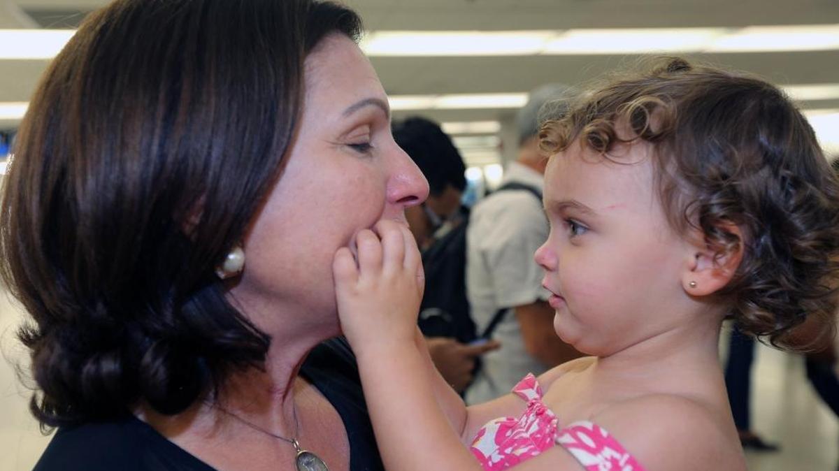 Isabel Padro de Castañer hugs her 2-year-old granddaughter Lucia at Miami International Airport after the child arrived on a flight from San Juan, Puerto Rico.