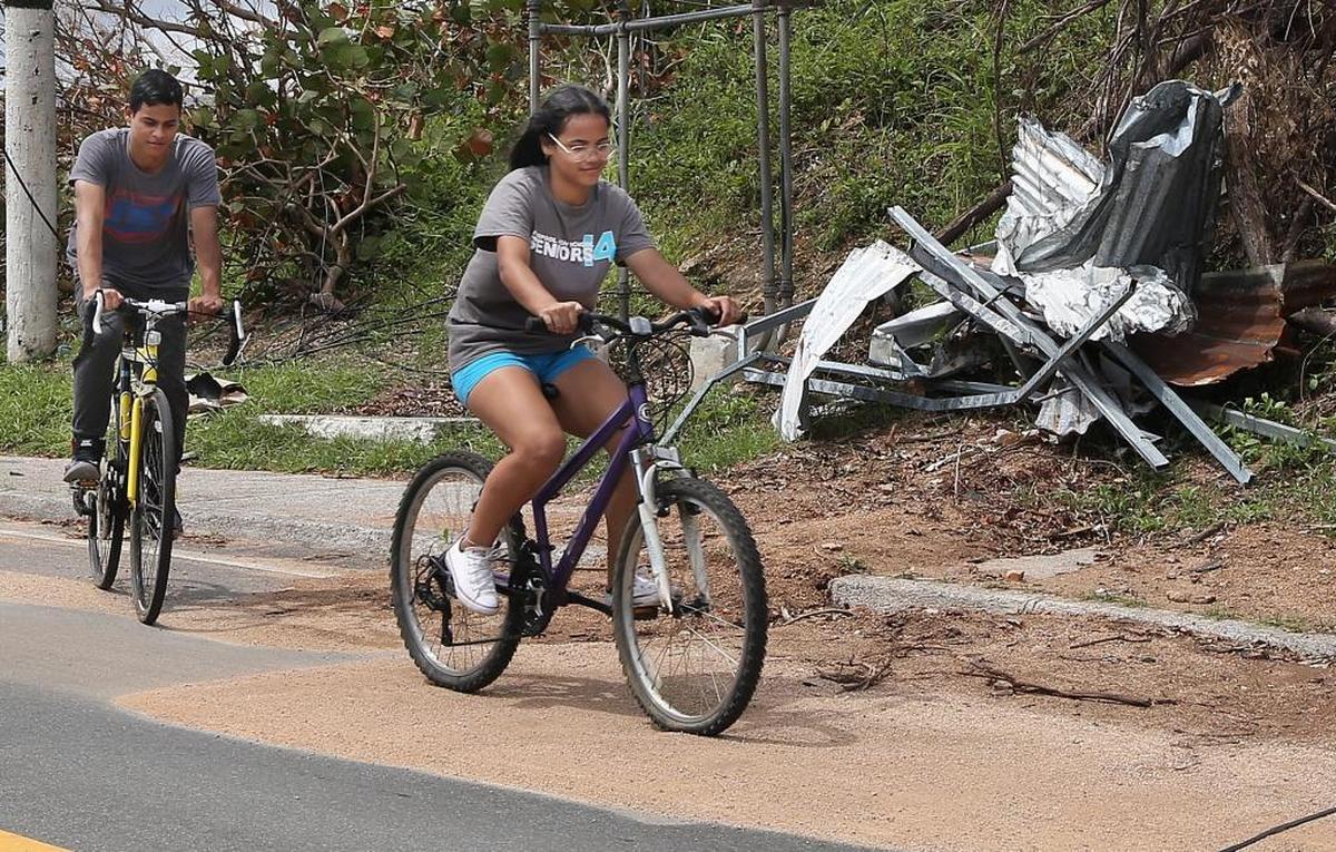 Brothers Angel and Yamaris Amaro bike to visit family in the town of Maunabo, Puerto Rico, where they’ve been staying since their house was destroyed by Hurricane Maria.