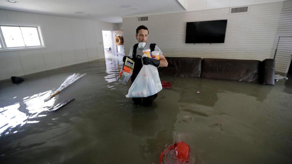 Gaston Kirby walks through floodwater inside his home in the aftermath of Hurricane Harvey, Monday, Sept. 4, 2017, near the Addicks and Barker Reservoirs, in Houston.