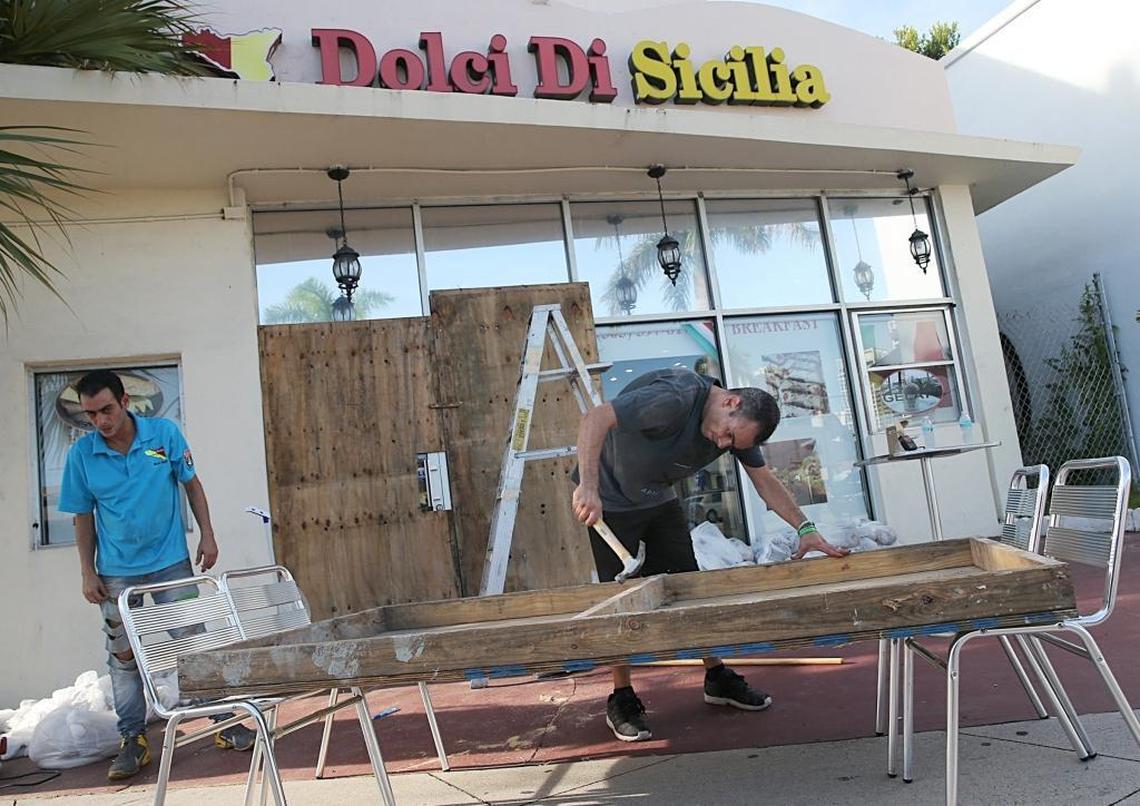 Owners and brothers Alessandro and Michael Latona board up their Dolce Di Sicilia Coffe Shop store front in Miami Beach as South Florida prepare for the coming hurricane Irma on September 07, 2017.