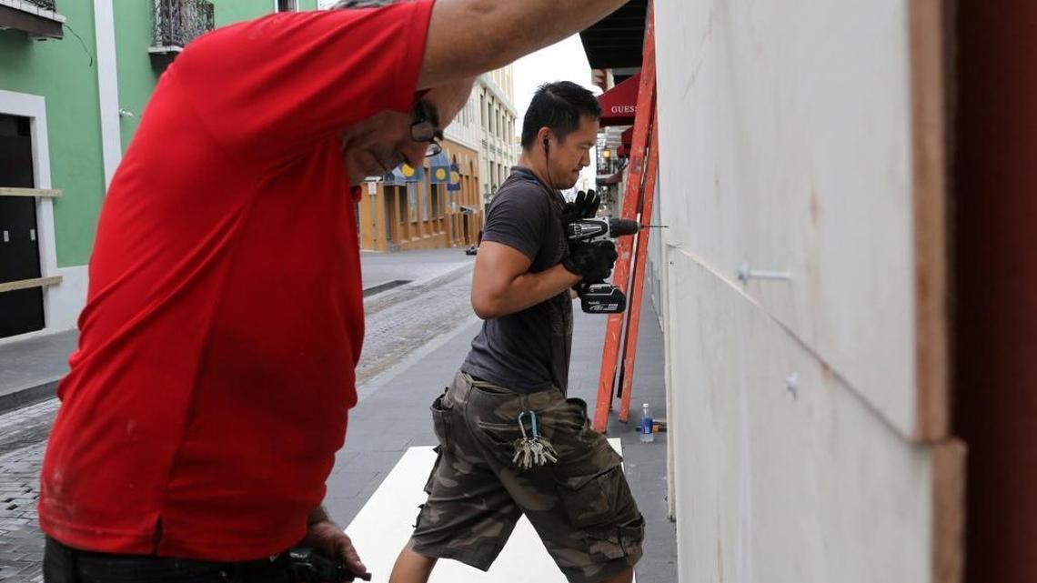 Handy men Daniel Hernandez, left, and Mario Baniaga, right, work quickly and efficiently to board up the windows for a client’s storefront in advance of Hurricane Maria at the historic Old San Juan in Puerto Rico on Tuesday, September 19, 2017.