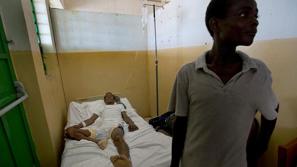 Arnold Dipo, 69, who was injured during Hurricane Matthew waits for medical help alongside his son at the Hospital Saint Antoine of Jeremie on Monday, October 10, 2016.