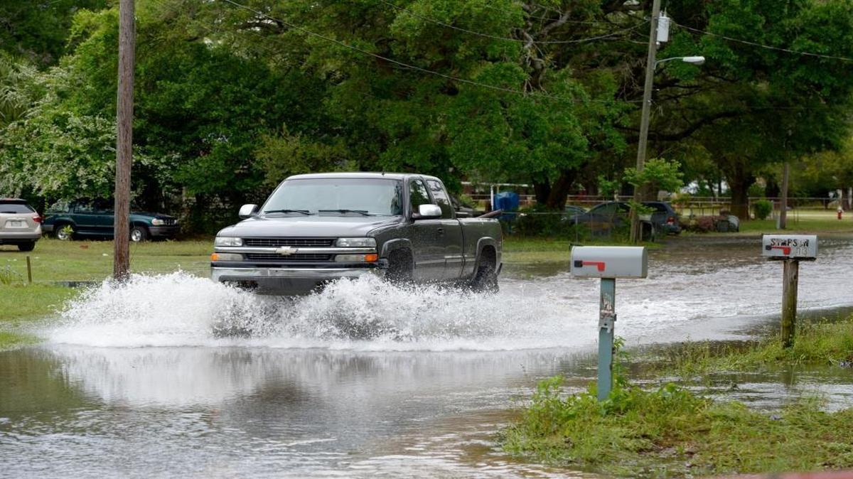 A truck drives along a still-flooded section of Bayliss Court as Gulf Coast residents continue cleaning up from damage caused by torrential rains in Pensacola, Fla., Thursday, May 1, 2014.