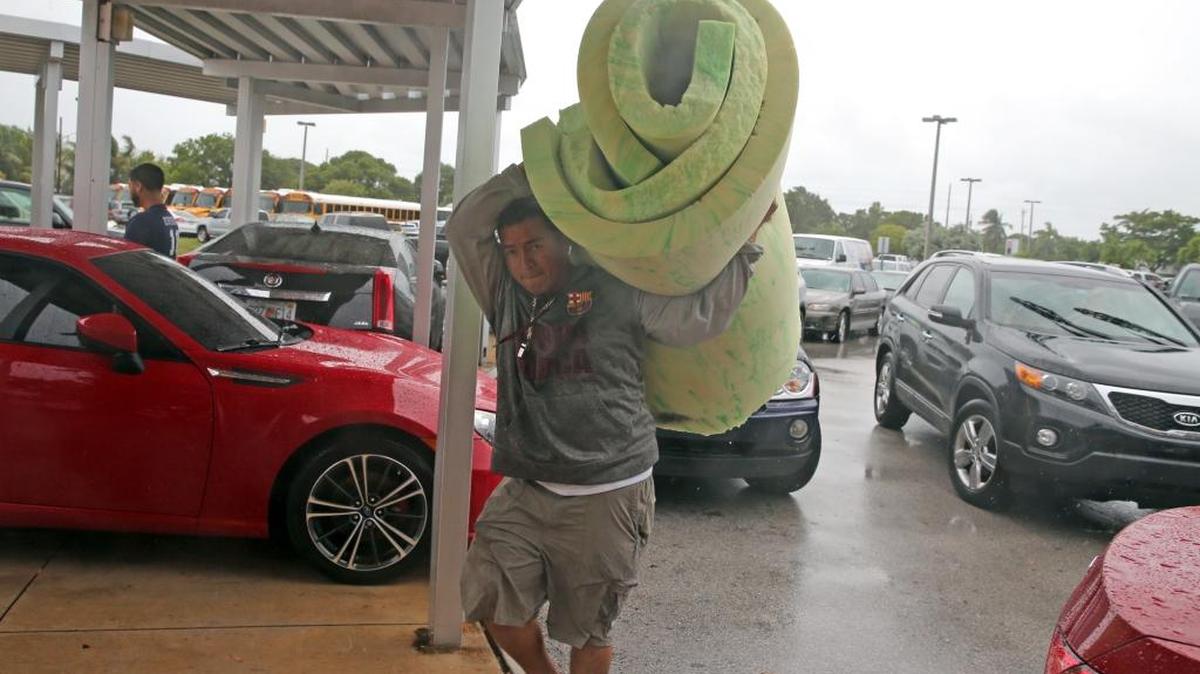 A Key West resident carries bedding into a shelter at Key West High School in Key West on Saturday as Hurricane Irma approached. The city opened a shelter of last resort for those who had not evacuated earlier. i