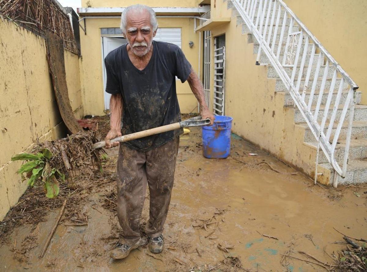 Ismael Freytes, 69, removes muddy debris as he tries to clean out his house in Arecibo, where the local river poured into the streets after Hurricane Maria.