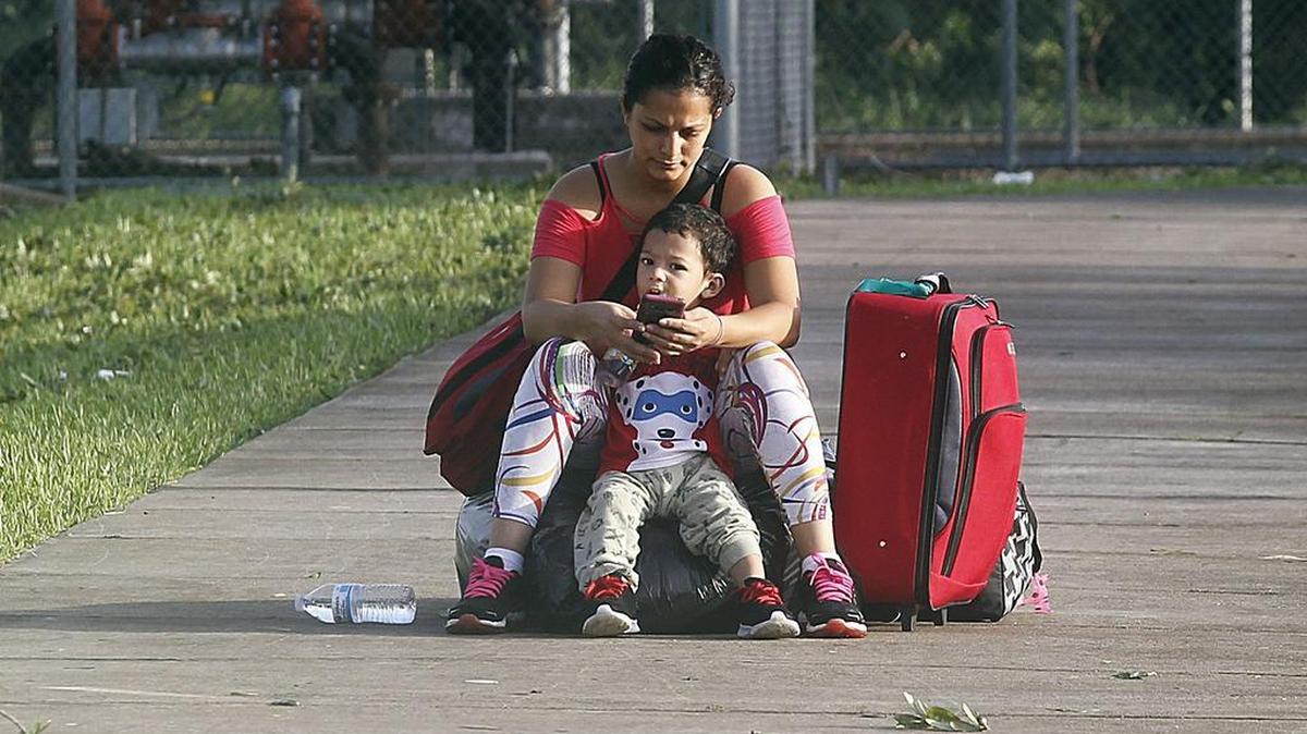 Yajaira Turcios and her son Eduard wait to be picked up to return home after spending three days at South Dade Middle School, a school turned hurricane shelter in Homestead, on September 11, 2017.