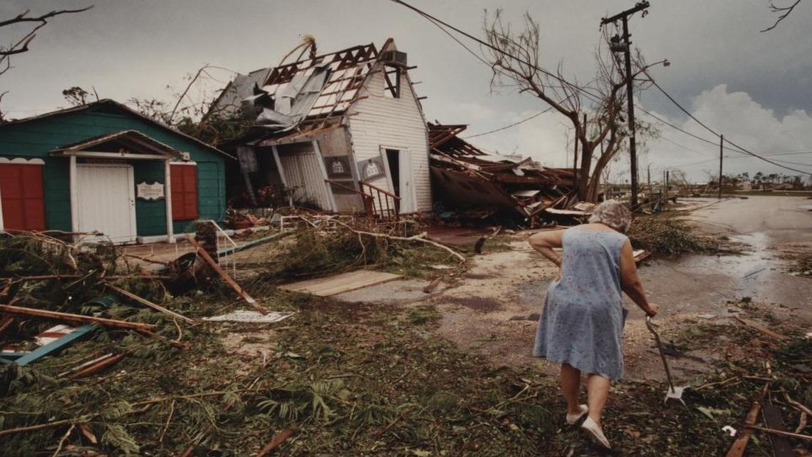 Hazel Mueller makes her way through the debris of the shops at historic Cauley Square near Goulds. Most of the curio and antique shops were badly damaged.