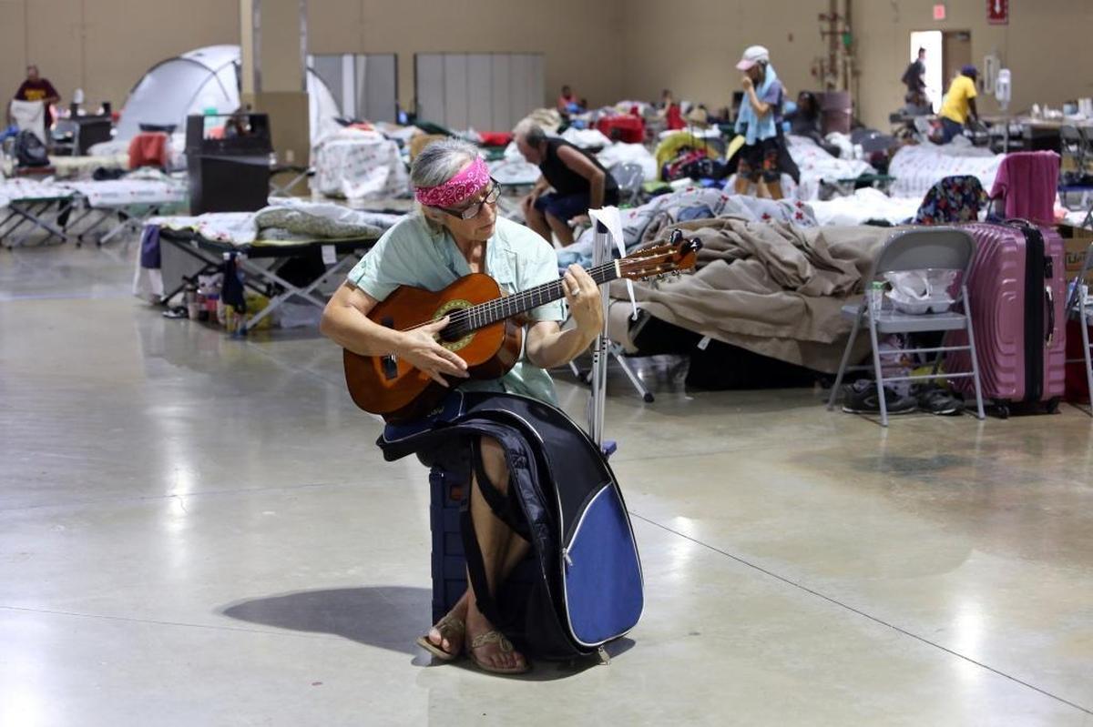 Linda Welsh, who evacuated her home in Miami and ended up at the E. Darwin Fuchs Pavilion at the Miami-Dade County Fairgrounds, plays the guitar and sings Spanish songs at the shelter, Thursday afternoon, Sept. 14, 2017. The E. Darwin Fuchs Pavilion is the only shelter remaining in Miami-Dade County. It’s housing about 1,000 people, including those who can’t get back to their homes in the Florida Keys after Hurricane Irma.