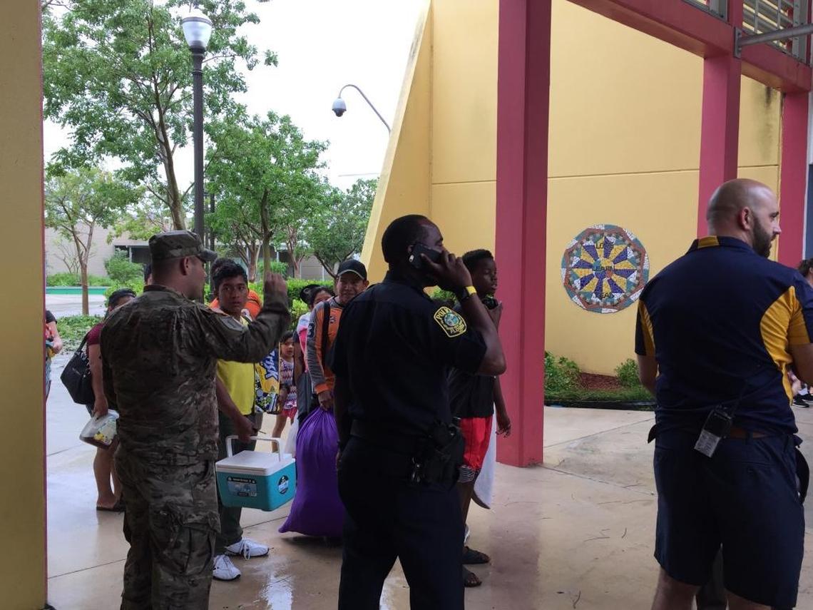 Principal John Galardi (right) and law enforcement urged evacuees to stay at South Dade Middle School on Sunday, Sept. 10 as many tried to leave the school turned shelter after winds from Hurricane Irma died down.