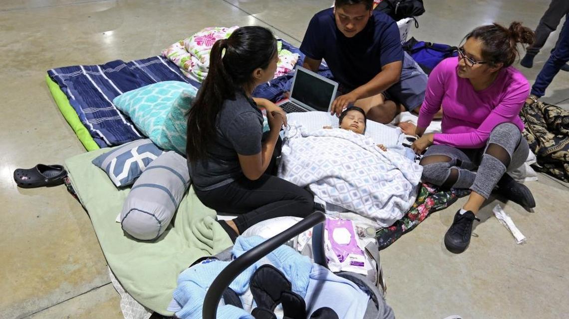 Nelly Diaz, left, and Albino Perez watch over their 2-month old son, Nicholas, along with his aunt, Nelly Diaz at the hurricane shelter at the Miami-Dade County Fair and Exhibition, ahead of Hurricane Irma.