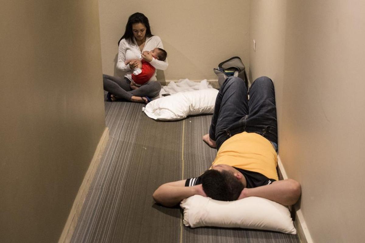 Adriana Rosado, 21, Jorge Diana, 24, and their 2-month old Jorge Nicolas, who live in Guaynabo, are guests at the Ciqala hotel as they wait in the hallway outside of their flooded room as Hurricane Maria bears down on Puerto Rico on September 20, 2017 in San Juan.