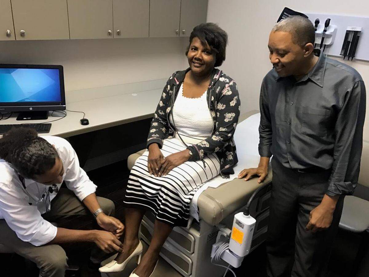 From left, Dr. Vladimir Derenoncourt tends to patient Sophia Alexandre as her husband, Ricardo Alexandre watches, at the Miami Beach Community Health Center’s clinic in North Miami. The clinic has been without power since Hurricane Irma and has been forced to turn away patients, said Evian White De Leon, a vice president.