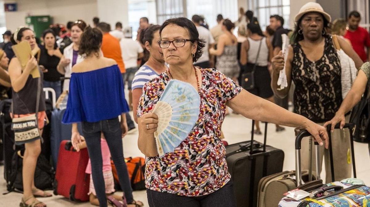 A woman fans herself as she stands in line with other travelers at Luis Muoz Marn International Airport in San Juan, Puerto Rico, on Sept. 25, 2017.