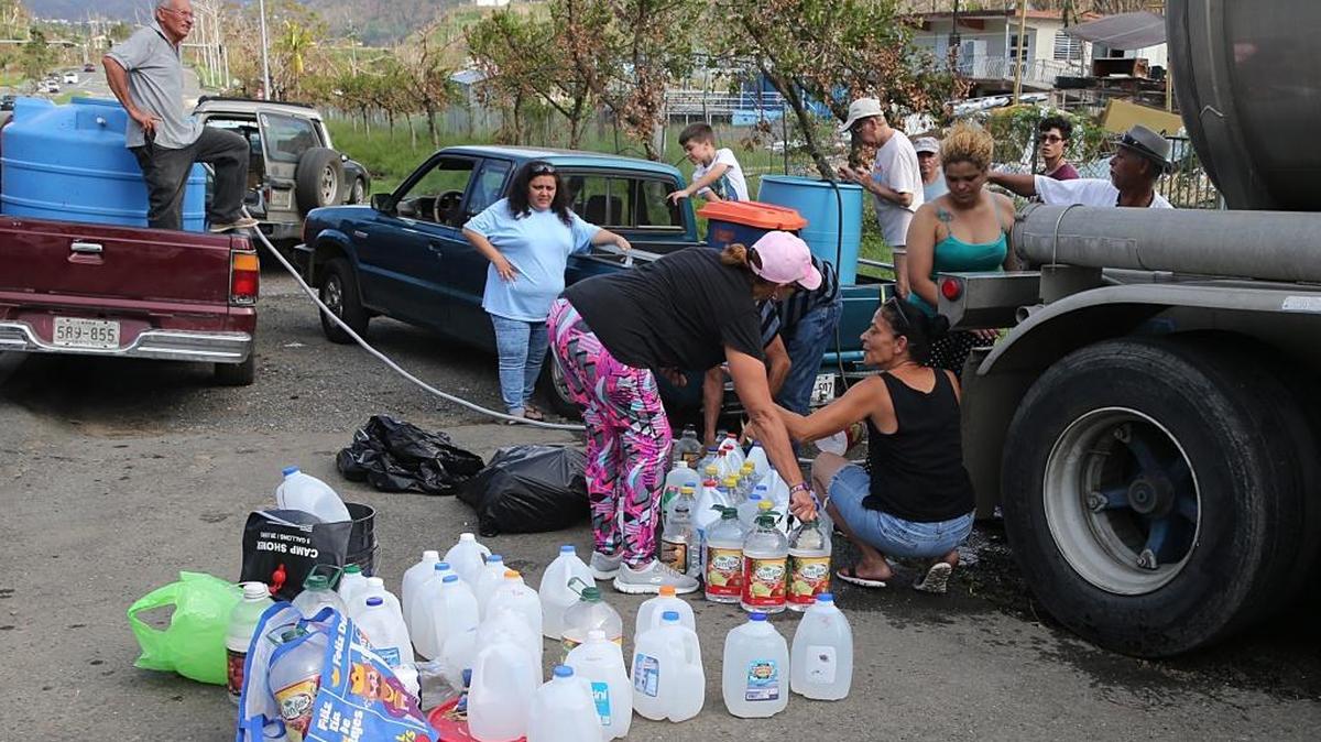 Residents line up to collect water from a tanker parked next to the road in Naranjito, Puerto Rico, in the aftermath of Hurricane Maria