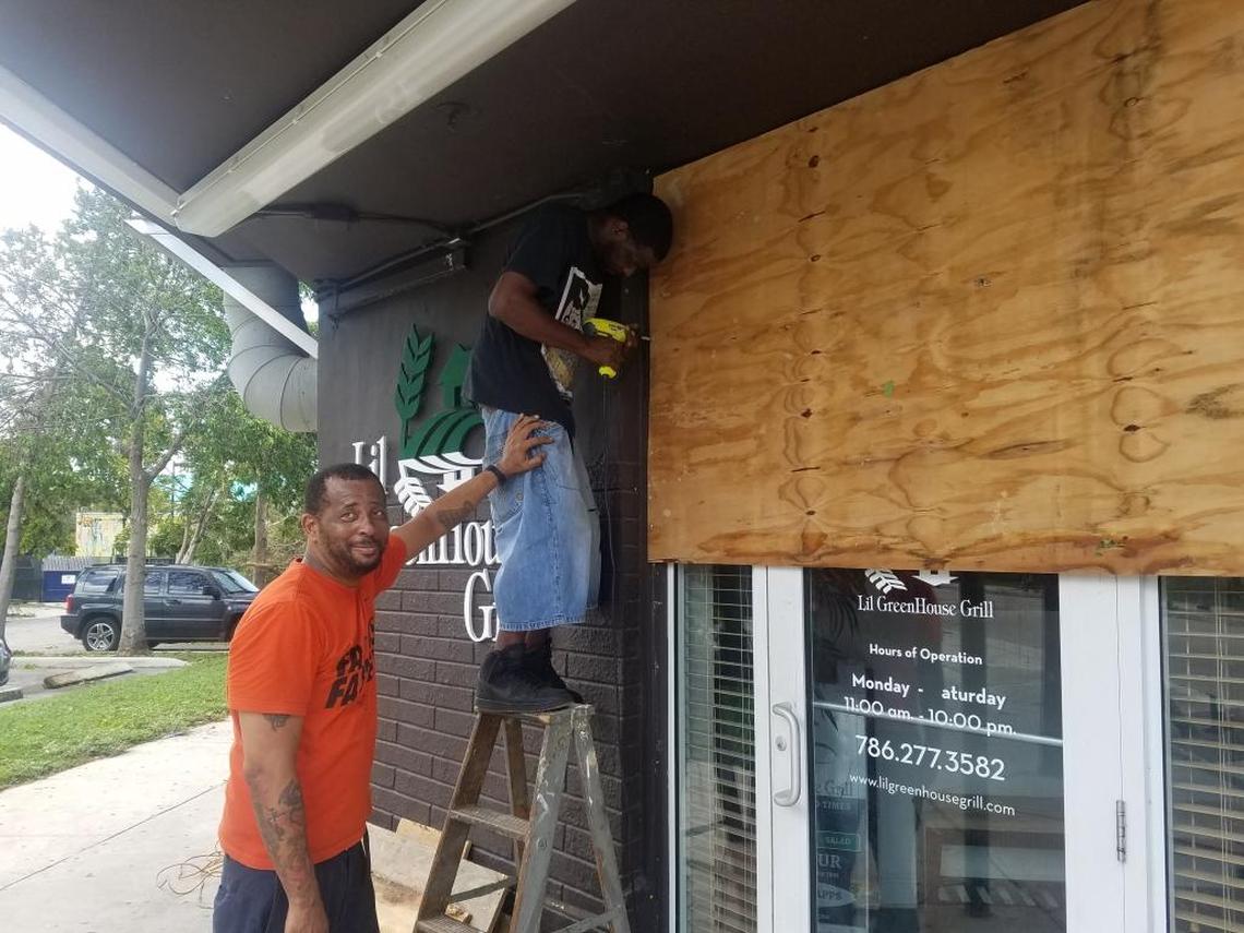 Karim Bryant, owner and head chef of the Lil Greenhouse Grill in Overtown, takes down plywood after Hurricane Irma.