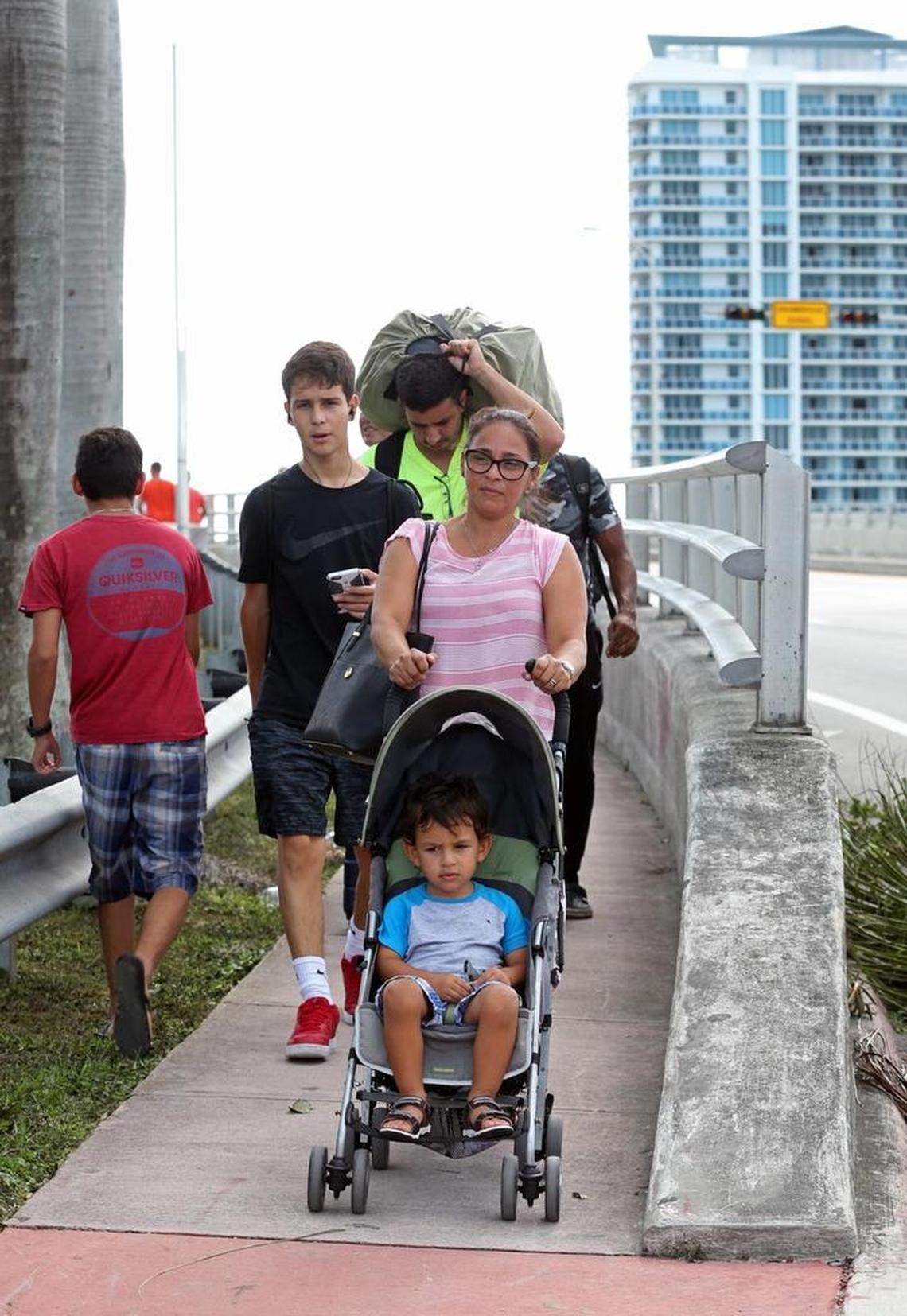 Lesly Lanza and her son Ivan Perez, 2, walk across the John F. Kennedy Causeway (79th Street Causeway) after evacuating to Bonita Springs for Hurricane Irma and now are returning home to North beach on Monday, September 11, 2017.