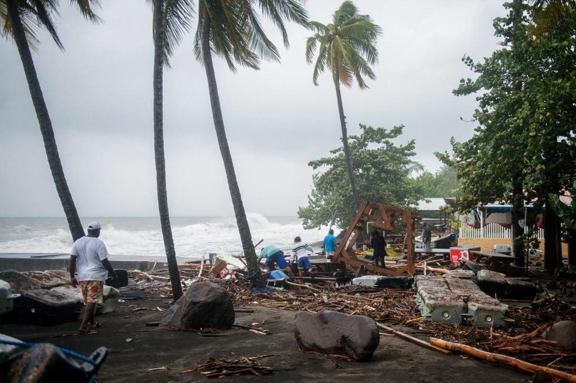 People walk among debris at a restaurant in Le Carbet, on the French Caribbean island of Martinique, after it was hit by Hurricane Maria. Martinique, a French island south of Dominica, suffered power outages but avoided major damage.