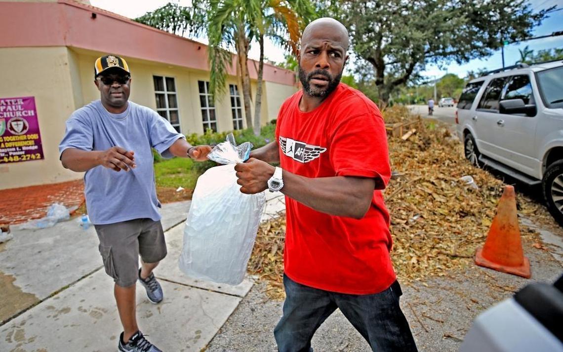 Ijamyn Grey, right, collects bags of ice at the Greater St. Paul A.M.E. Church for distribution to residents without power in Coconut Grove on Saturday, September 16.