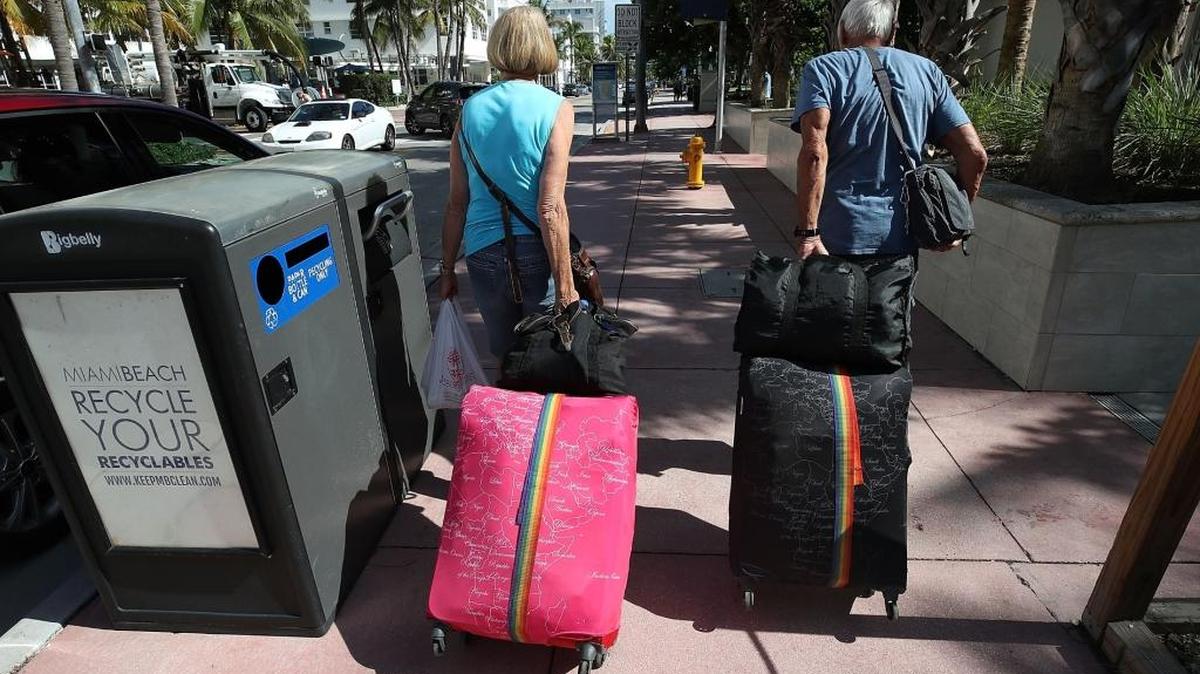 Miami Beach is under mandatory evacuations. Tourist Bjorg Aasen and Arne Forsmo walk to catch a shuttle to a shelter as the city announced a mandatory evacuation ahead of the approaching Hurricane Irma on September 7, 2017 in Miami Beach, Florida.