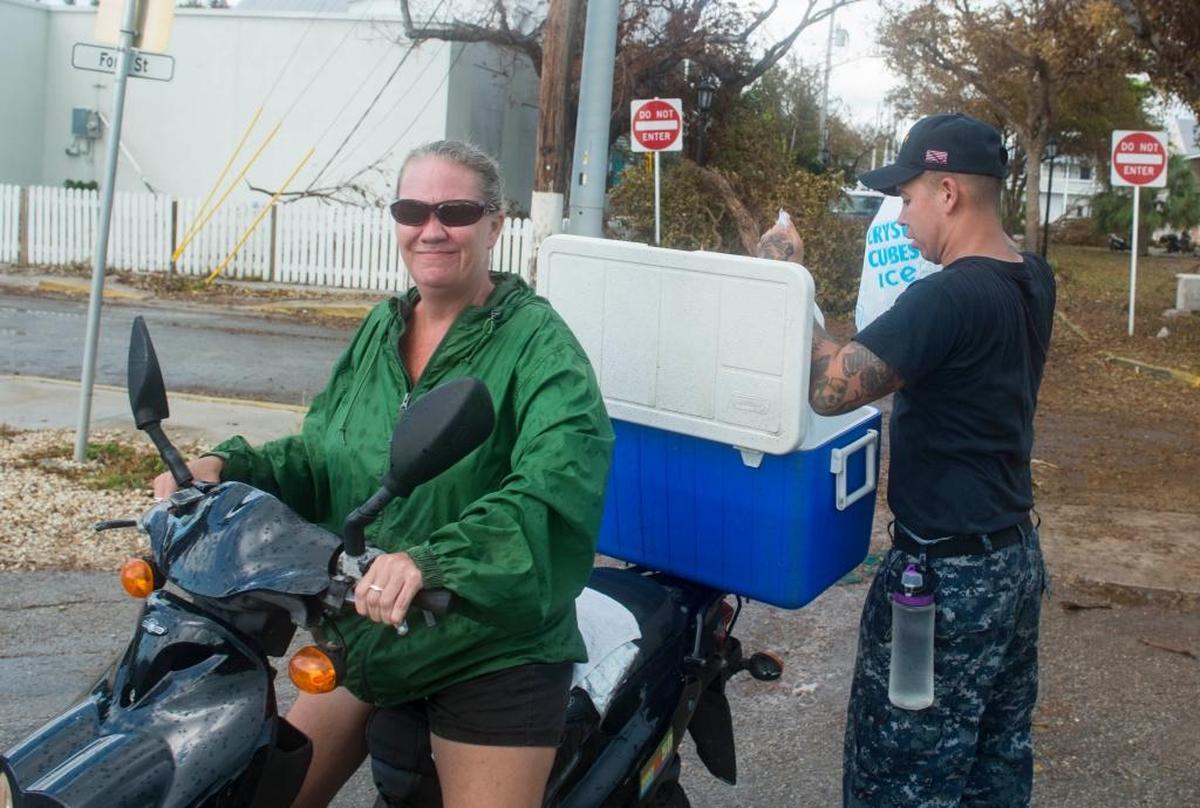 Airman Apprentice Raymond Eldridge, from Washington, D.C., gives ice to a resident of Key West, during humanitarian relief efforts following Hurricane Irma’s landfall.
