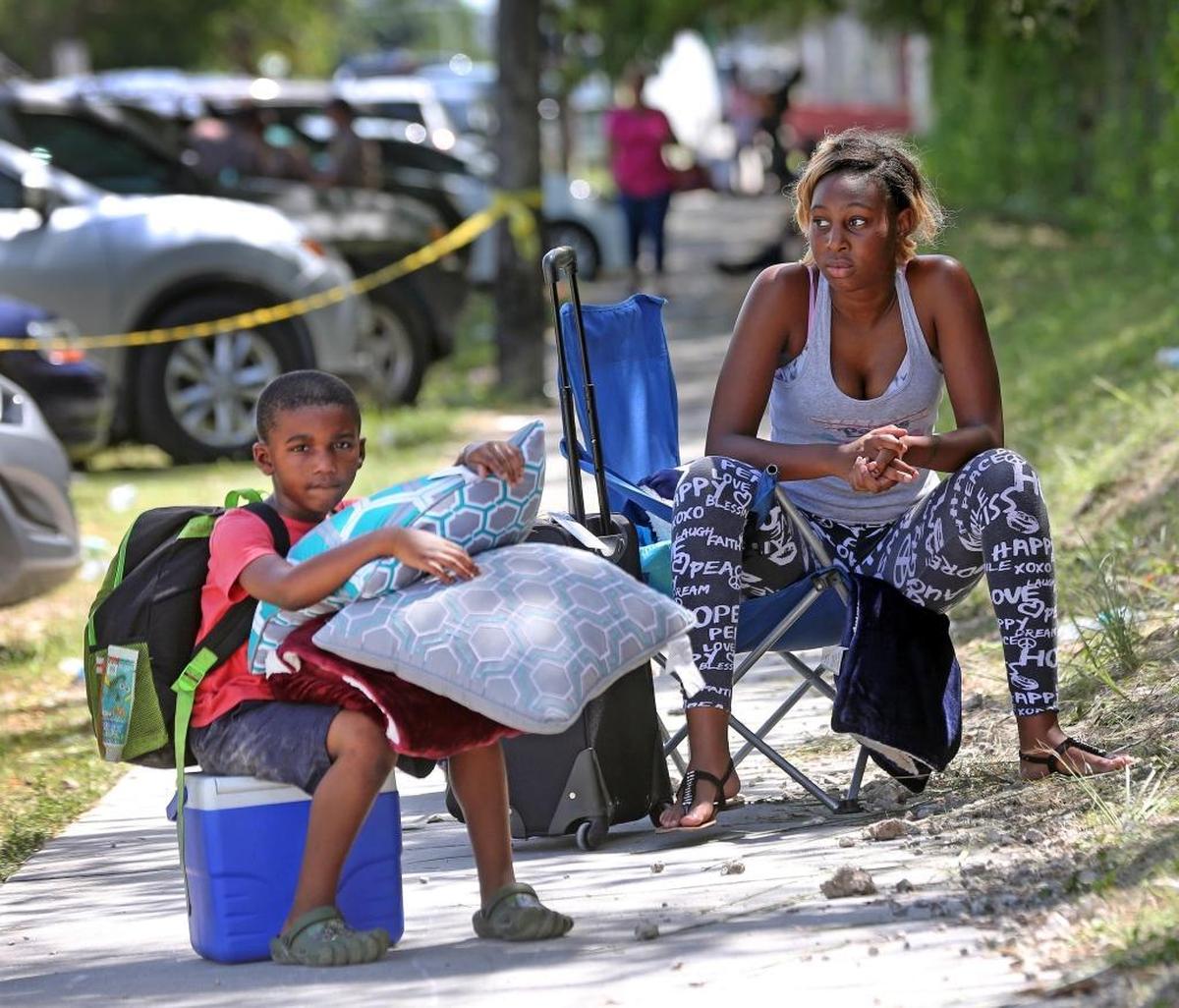 Tommiesha Gaines and her cousin King James Carter, 6, wait in the sidewalk after not being able to make it into the Robert Morgan Educational Center shelter, which filled up to capacity at 2,400 people on Friday, September 8, 2017.