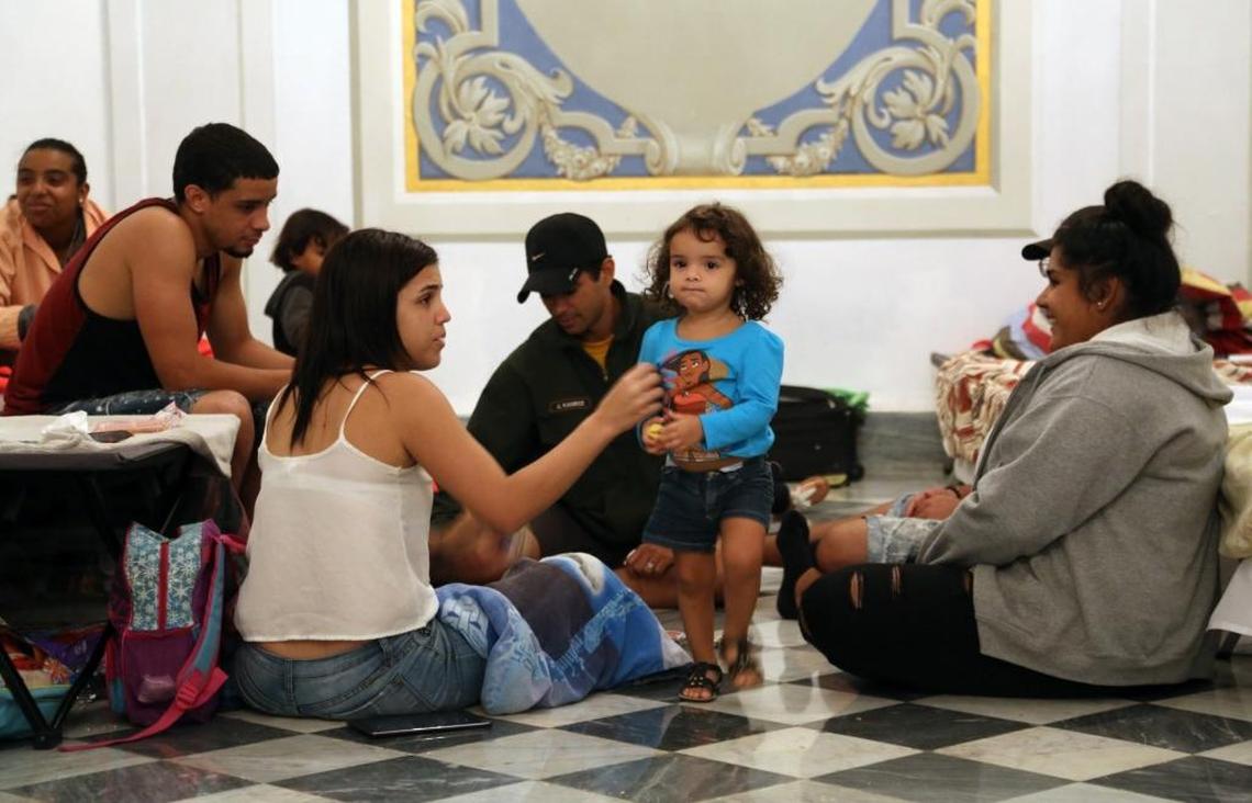 Families share a game of cards as they and other residents of Old San Juan take advantage of the open hurricane shelter at City Hall in advance of Hurricane Maria in Puerto Rico on Tuesday.