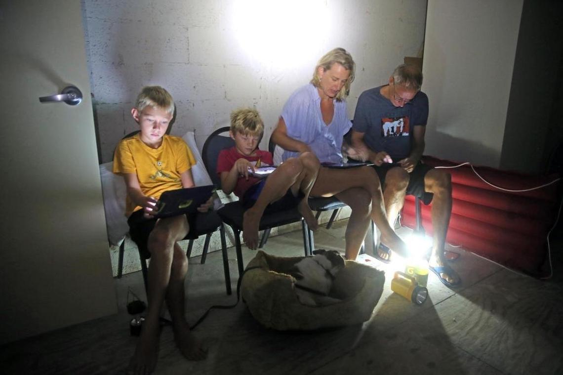 Blinckman family sits in a stairwell utility closet on Eaton Street, as Hurricane Irma's eyewall nears Key West, Sept. 10, 2017