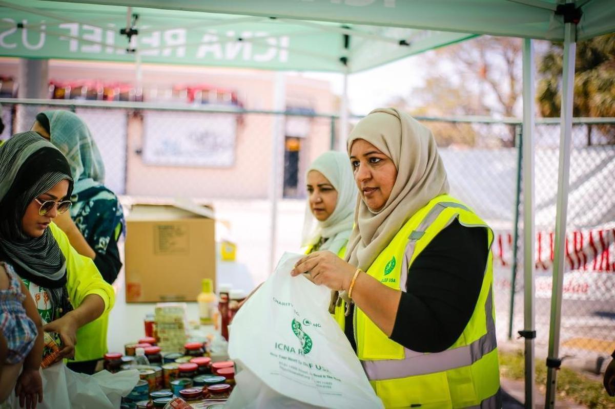 Islamic Circle of North America Relief USA volunteer Shaza Cheema (R) fills bags of canned foods for residents of Liberty City effected by Hurricane Irma at the Masjid Al-Ansar mosque in Miami, Fla.