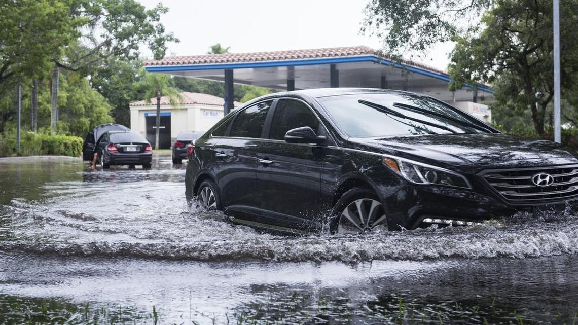 A car tries to exit the gas station through the flooded exit at Sawgrass Mall on Wednesday, June 7, 2017.
