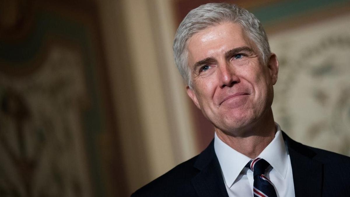 Supreme Court nominee Neil Gorsuch looks on as Senate Judiciary chairman Sen. Chuck Grassley (R-IA) speaks to reporters before their meeting on Capitol Hill.