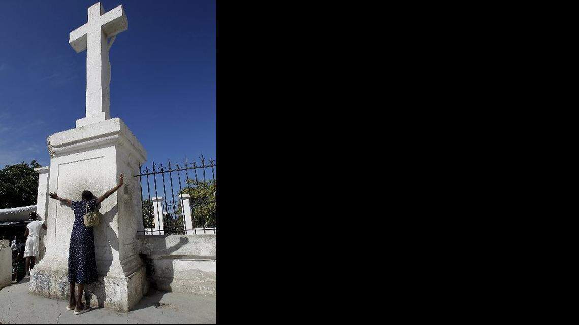 
REMEMBRANCE: A woman prays for loved ones lost in the Haiti earthquake at an undamaged cross.
