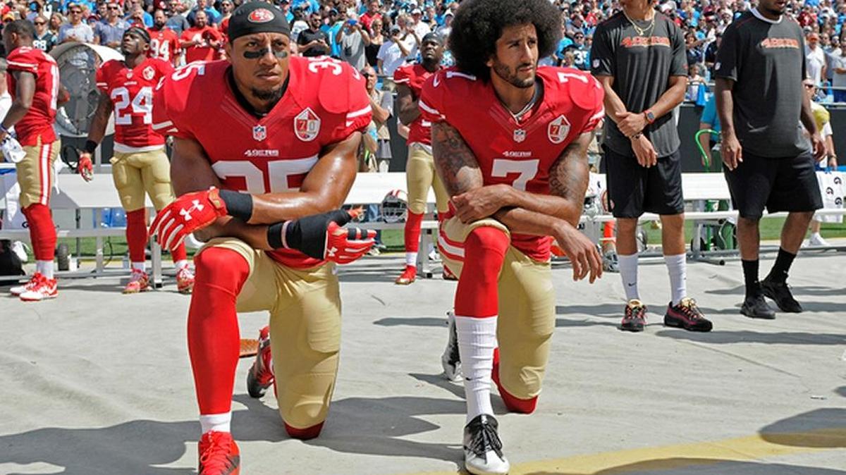 Former San Francisco ’49ers QB Colin Kaepernick (right) and Eric Reid take a knee during the national anthem before a game.