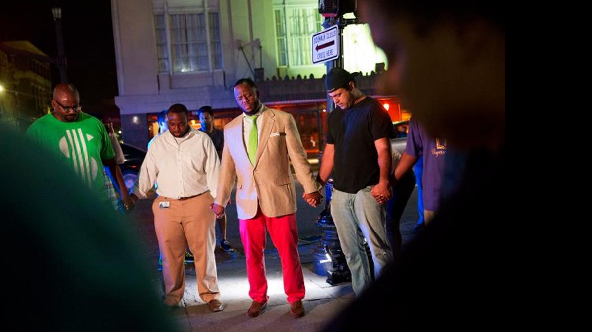 
IN PRAYER: Worshipers gather down the street from the Emanuel AME Church following a shooting in which nine were killed.
