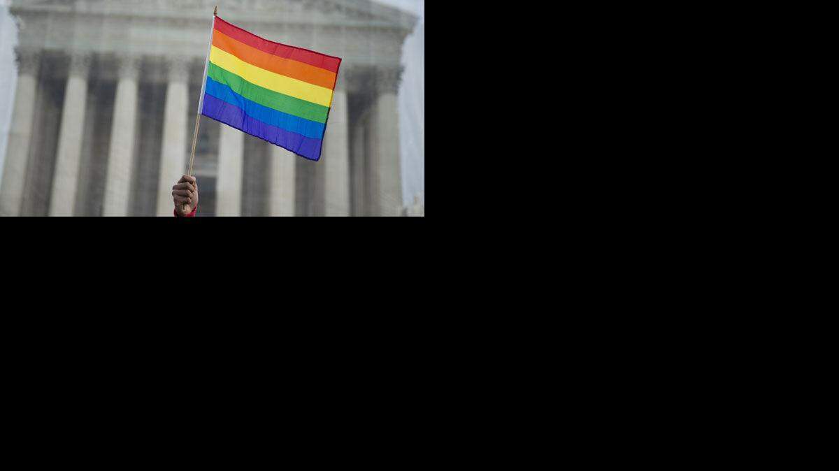 
Advocate waves the rainbow flag of the gay-rights movement in front of the U.S. Supreme Court.
