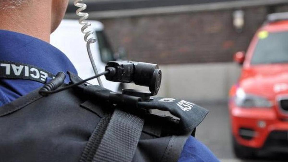 
Police officer wears a shoulder-mounted camera. 

