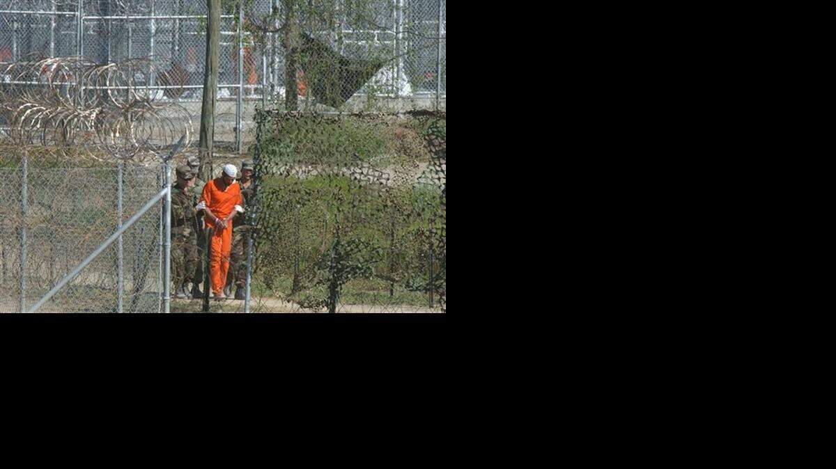 
IN DETENTION: In this March 1, 2002 file photo, a detainee is escorted to interrogation by U.S. military guards at Camp X-Ray at Guantánamo Bay U.S. Naval Base, Cuba. 
