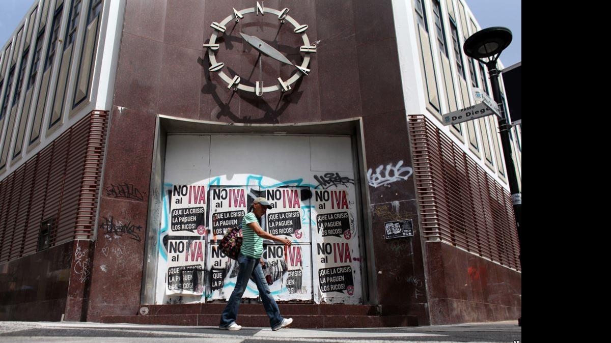 
A woman walks in front of a closed bank in the neighborhood of Rio Piedras in San Juan, Puerto Rico.
