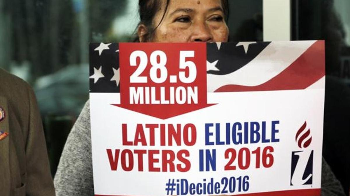 Georgina Arcienegas holds a sign in support of Latino voters during a protest outside the office of Florida Rep. Carlos Trujillo in Doral.