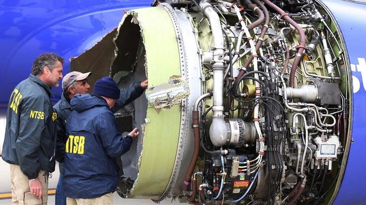 National Transportation Safety Board investigators examine damage to the engine of the Southwest Airlines plane that made an emergency landing at Philadelphia International Airport on Tuesday.