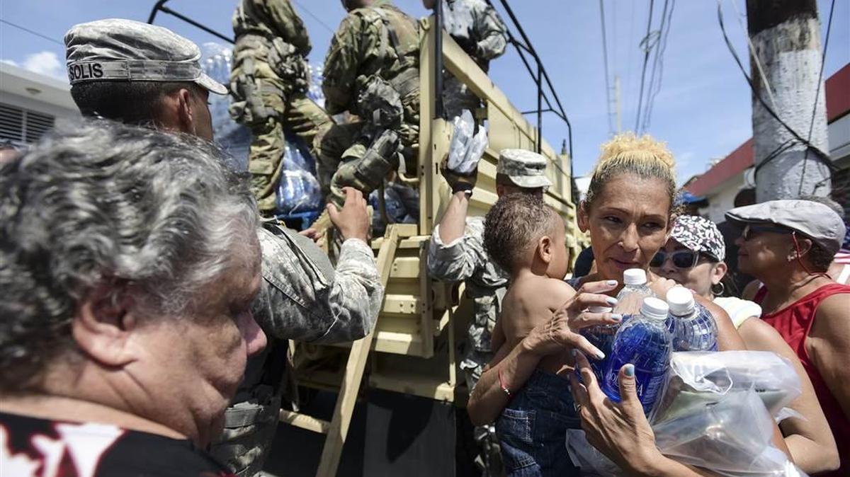 National Guard soldiers arrive at Barrio Obrero neighborhood in San Juan on Sunday to distribute water and food.