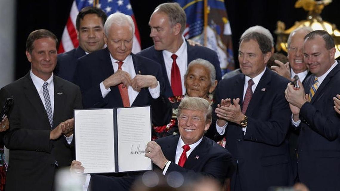 President Donald Trump holds up a signed proclamation to shrink the size of Bears Ears and Grand Staircase Escalante national monuments at the Utah State Capitol on Monday.