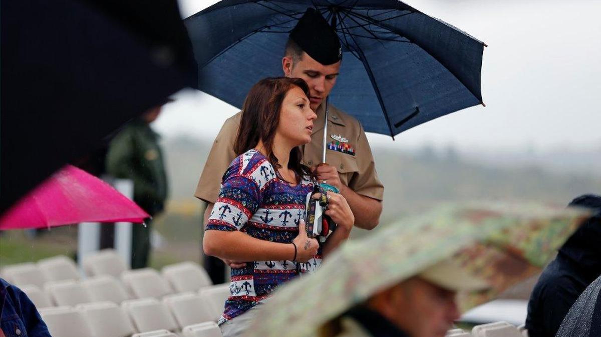 
TRIBUTE: Andrew and Angela Garrison of Johnstown, Pa., stand under an umbrella as rain falls at the dedication of the Flight 93 National Memorial Visitor Center in Shanksville, Pa.
