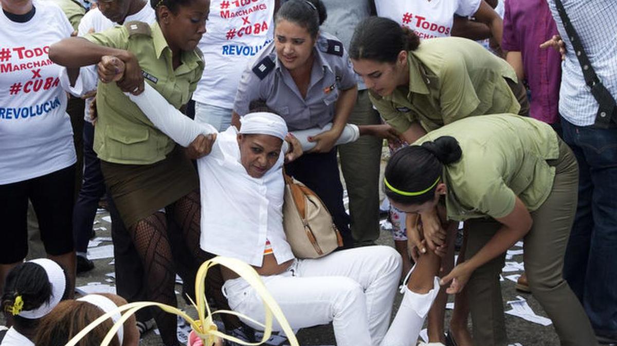 Policewomen drag away a member of Ladies in White, a dissident group that calls for the release of political prisoners.