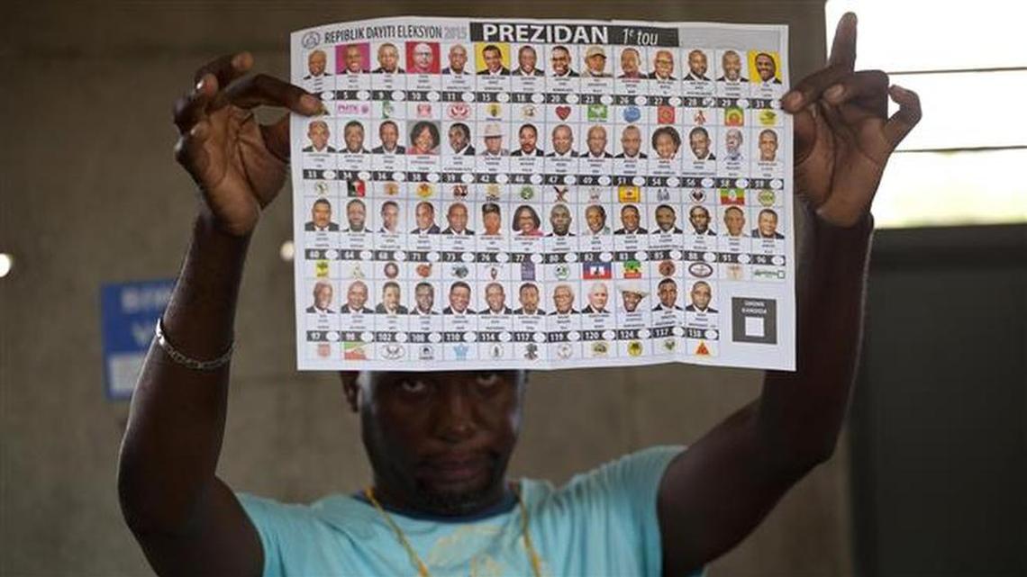 An electoral worker holds up a presidential ballot during October elections in Port-au-Prince. A runoff is scheduled for Sunday.
