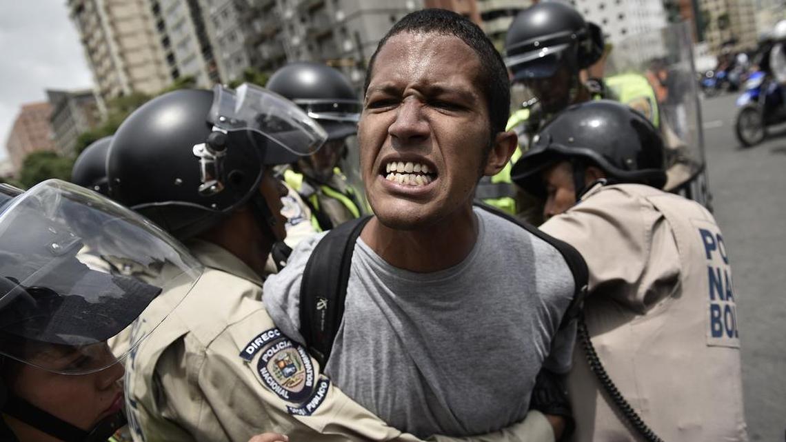 A protester is detained by Venezuelan police Wednesday during street clashes over a presidential recall referendum.